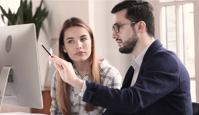 Dois colaboradores analisando dados em um computador